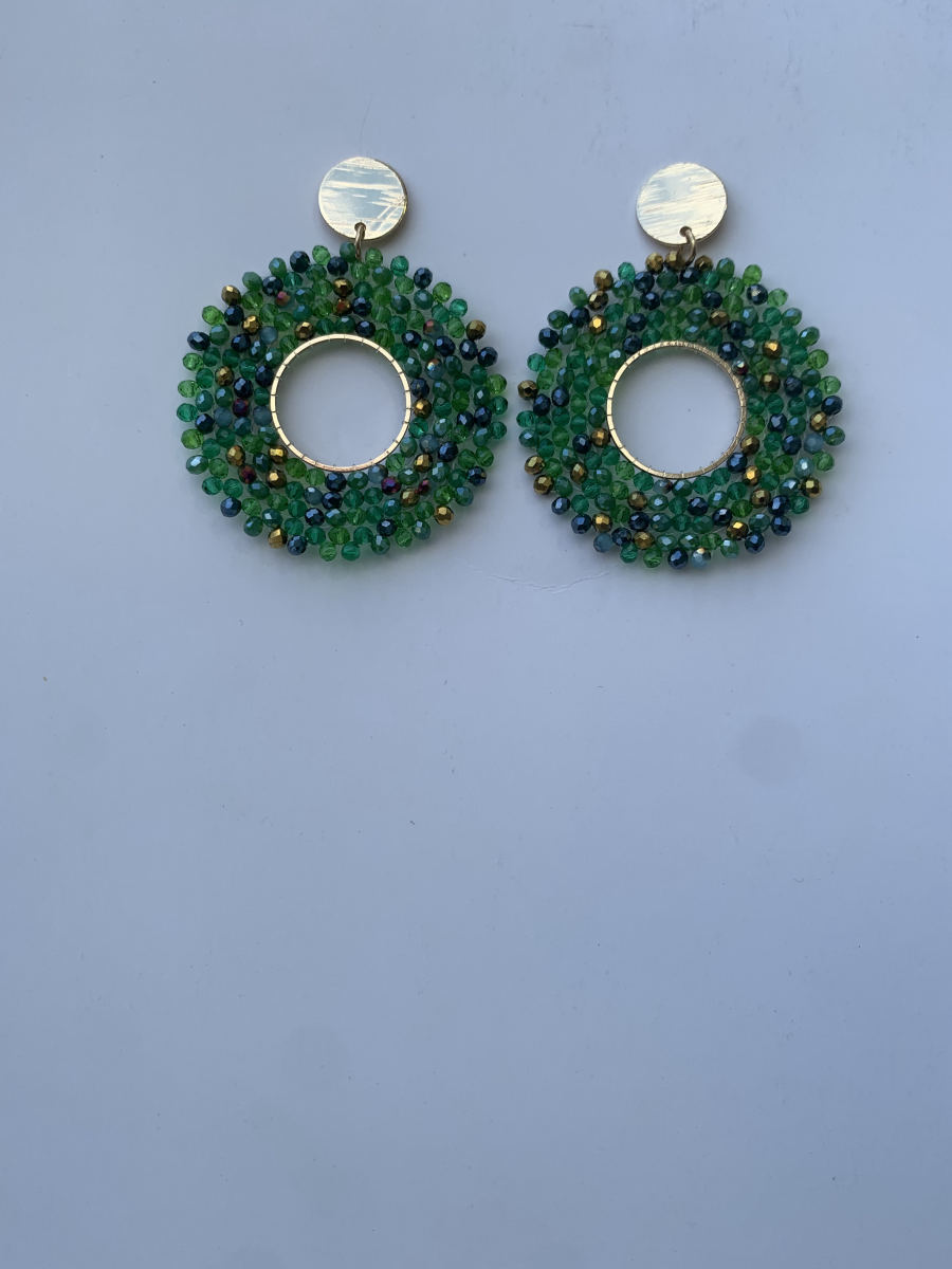 Large open circle hoop earrings densely covered in mixed green and iridescent dark navy faceted crystals, gold disc stud top.